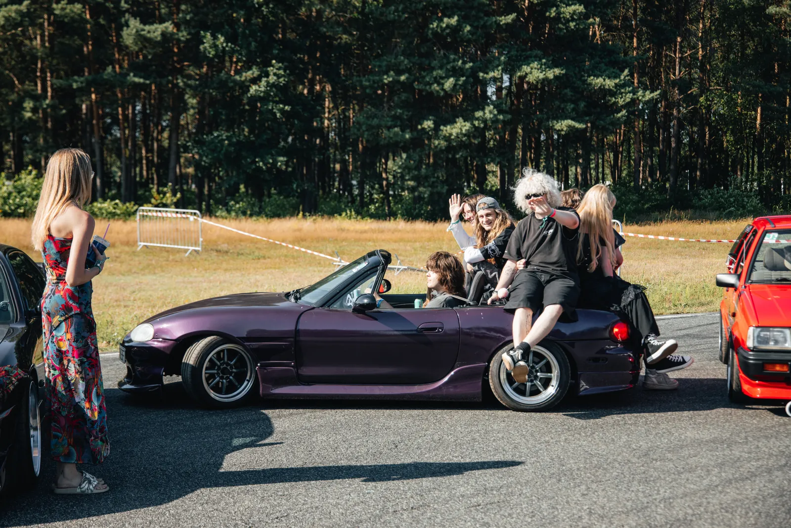 People gathered around a purple sports car